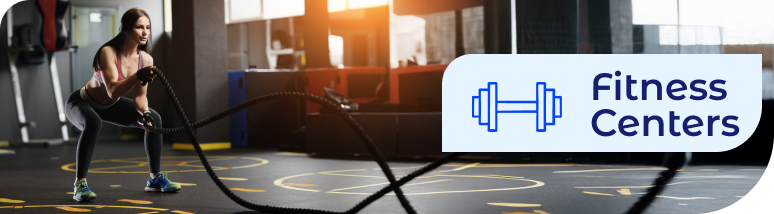 Fitness Centers service banner showing a woman exercising with battle ropes in a sanitized gym, illustrating specialized commercial cleaning and janitorial services for health clubs.